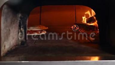 披萨是在传统的木材燃烧比萨饼面包餐厅烤箱烘烤。 厨师比萨饼师烹饪比萨饼餐厅